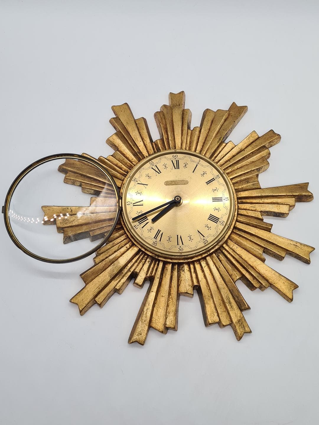 Wall Clock Sunburst, gold composite, black metal, glass, Germany, 1970s. - 326827