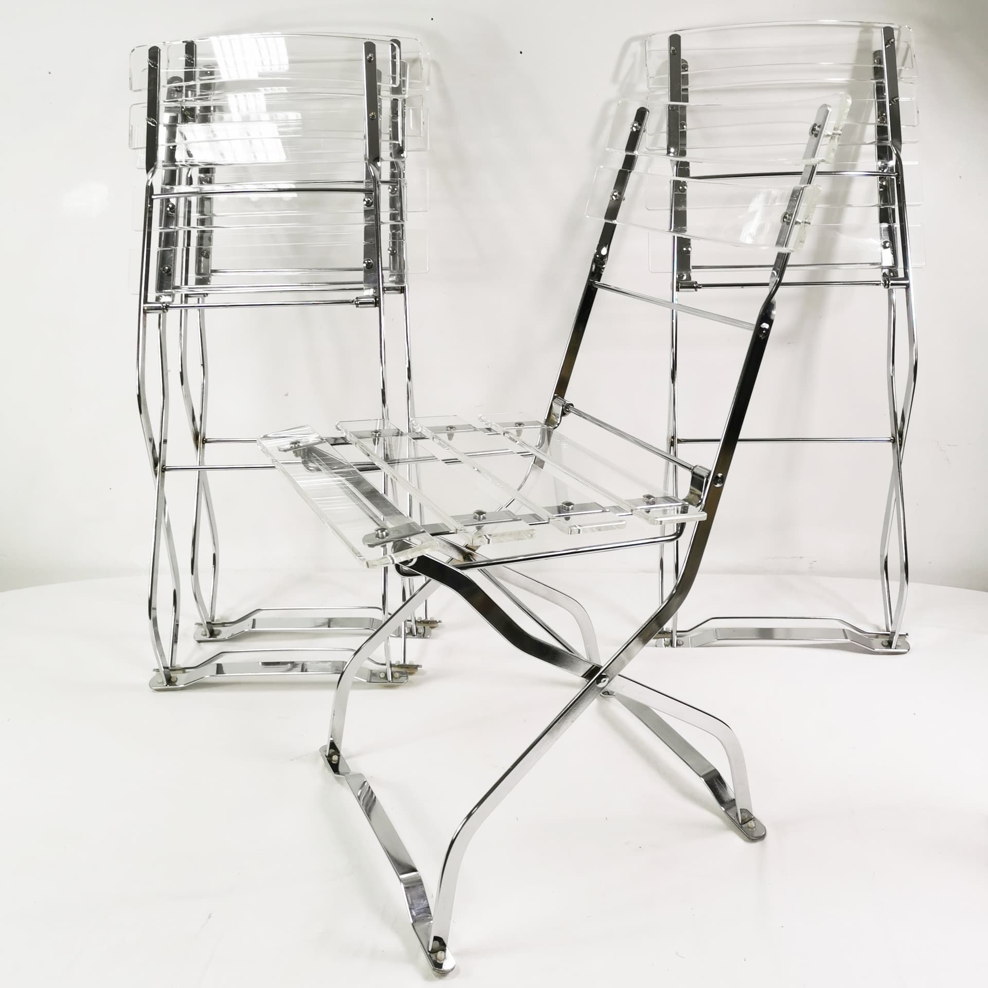 Set of four folding chairs, transparent plexiglass, silver metal, France, 1970s. - 347521