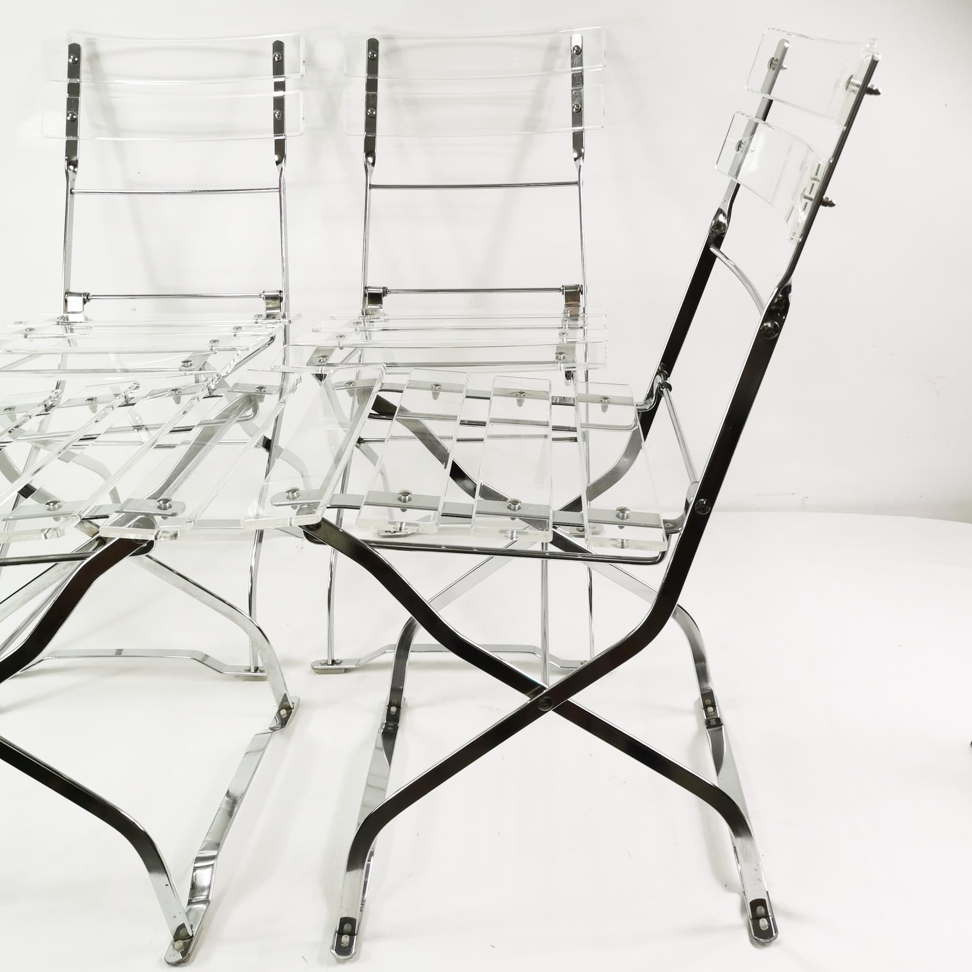 Set of four folding chairs, transparent plexiglass, silver metal, France, 1970s. - 347510