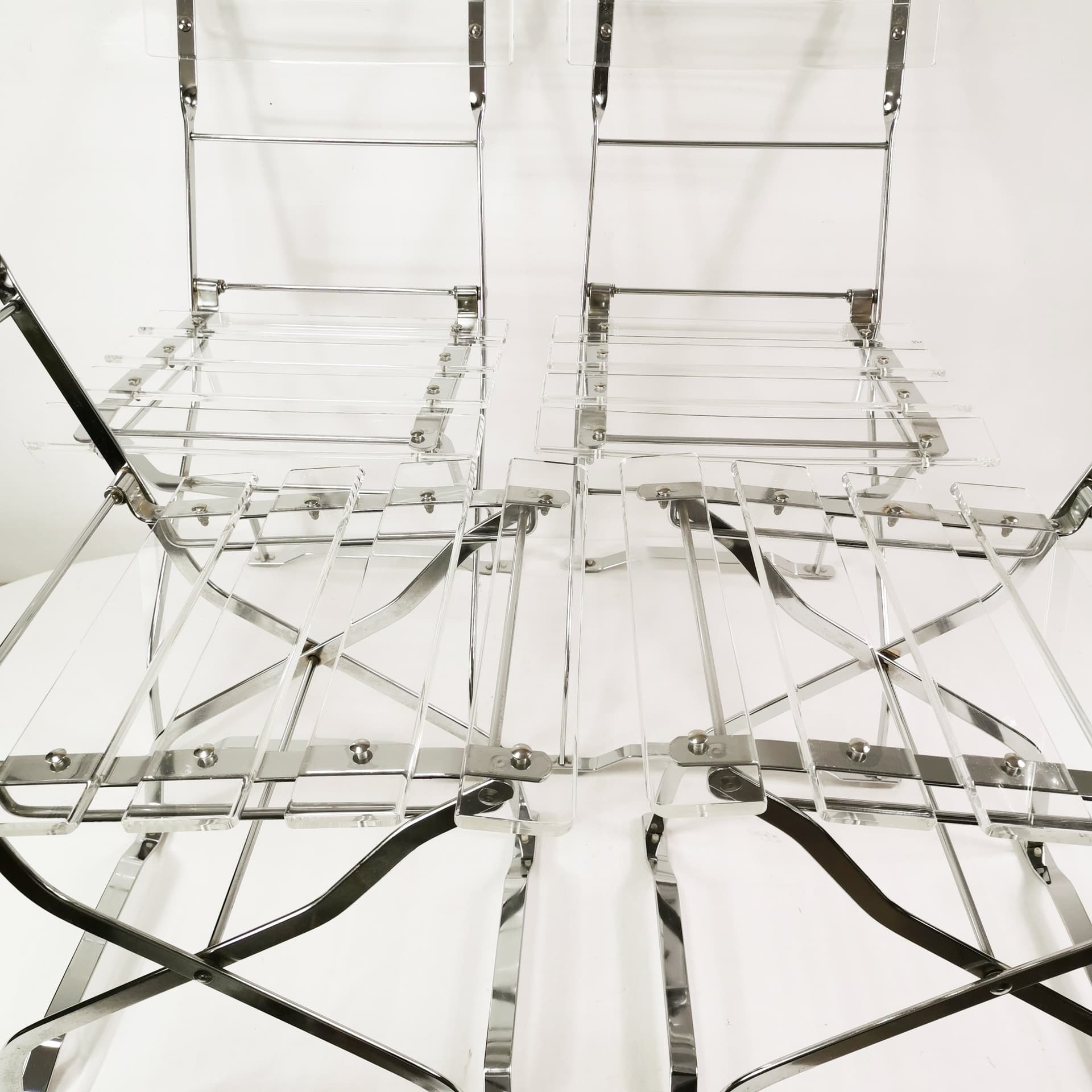 Set of four folding chairs, transparent plexiglass, silver metal, France, 1970s. - 347511