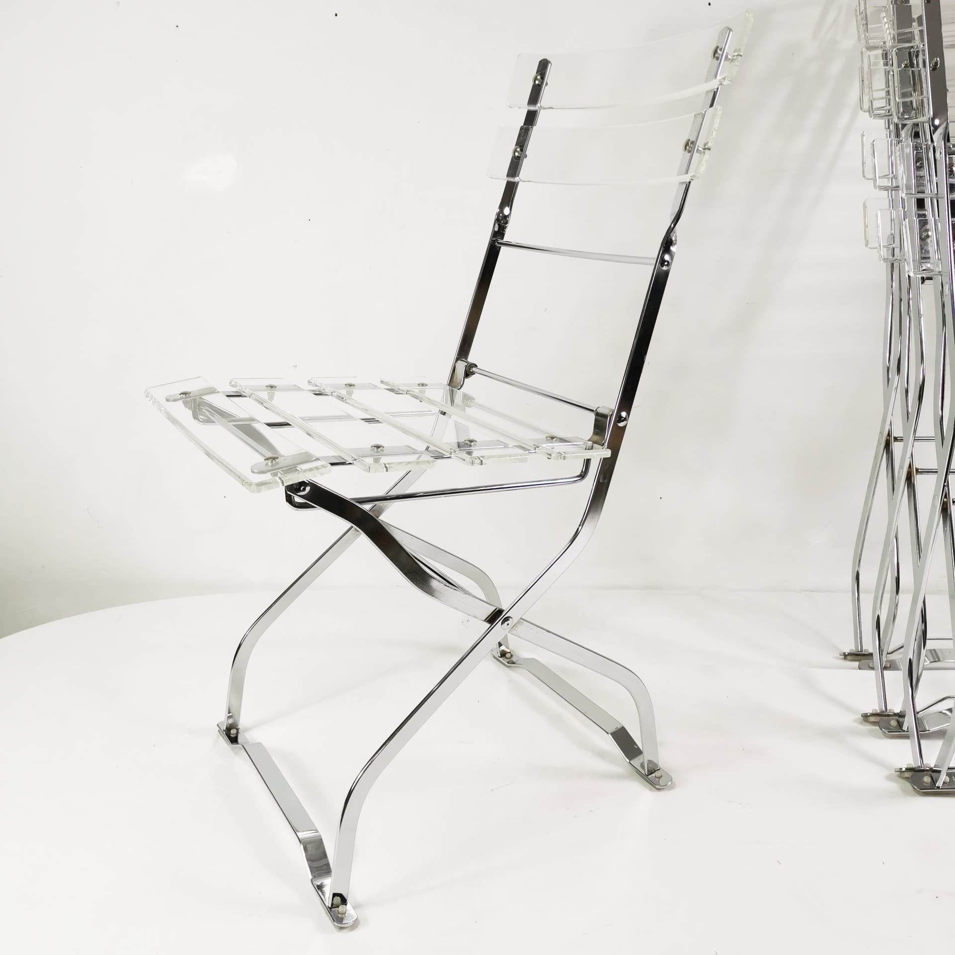 Set of four folding chairs, transparent plexiglass, silver metal, France, 1970s. - 347514