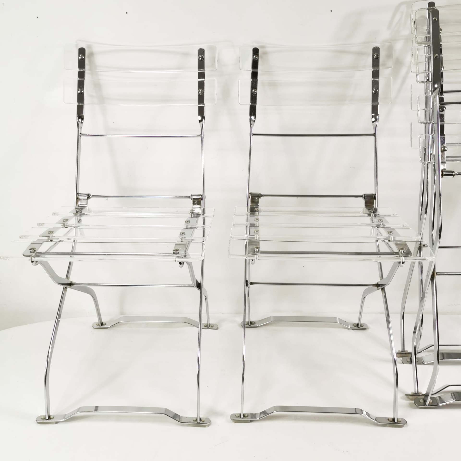 Set of four folding chairs, transparent plexiglass, silver metal, France, 1970s. - 347512