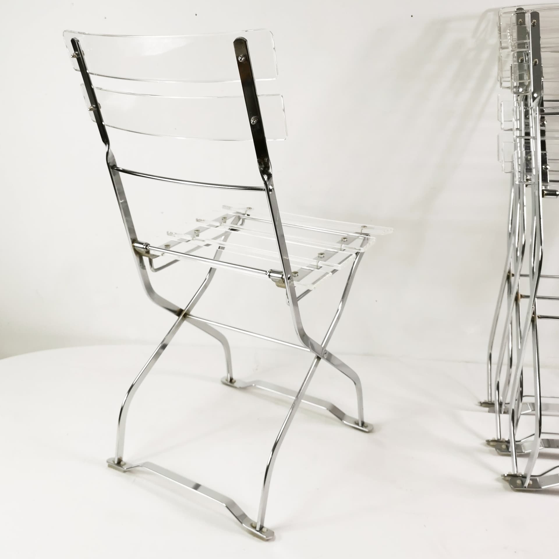 Set of four folding chairs, transparent plexiglass, silver metal, France, 1970s. - 347517