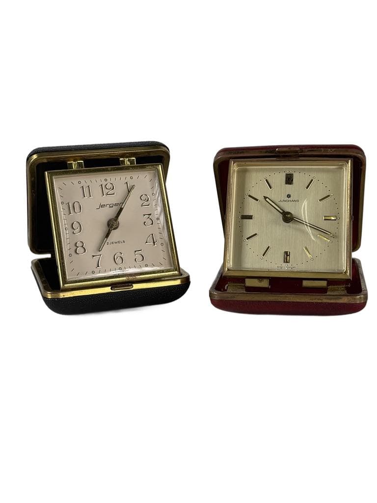 Set of two travel clocks, Junghans & Jerger, gold brass, black and burgundy faux leather, Germany, 1960s.